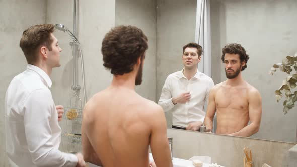 Young Athletic Gay Couple in Front of Mirror in Morning at Bathroom.