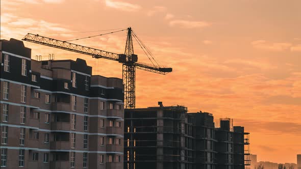 Timelapse of a Working Construction Crane Against Backdrop Beautiful Sunset Sky