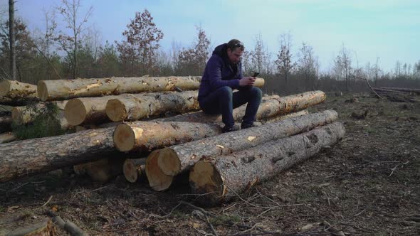 Lumberman Typing Sms on Smart Phone Outdoors