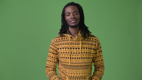 Young Handsome African Man with Dreadlocks Against Green Background