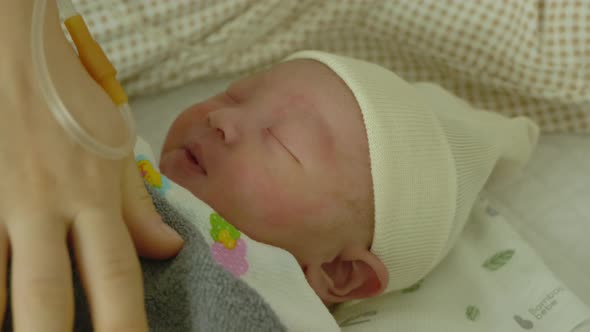 Newborn baby sleeping in mother's arms.