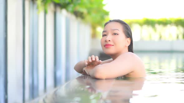 Young asian woman enjoy around outdoor swimming pool for leisure