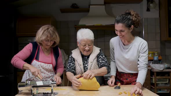 Cheerful women cooking tortellini in kitchen together