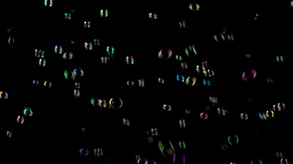 Medium Soap Bubbles Spinning. Black Background.