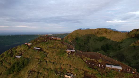 tourists in huts during sunrise golden hour at Mount Batur volcano in Bali Indonesia, aerial