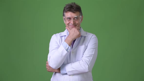 Mature Handsome Man Doctor Against Green Background