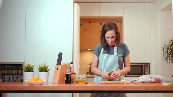 A Woman Cuts Garlic on a Cutting Board