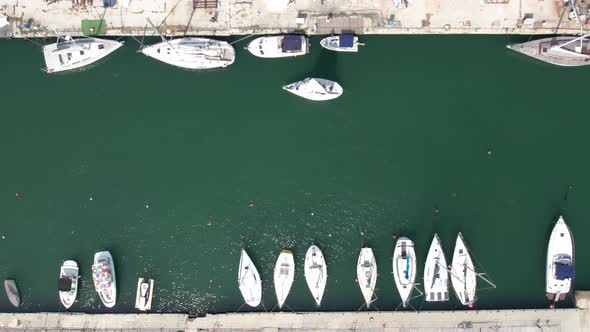 Aerial top down view of yacht leaving yacht club.