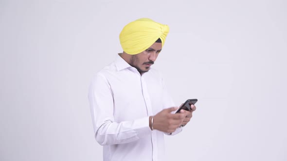 Stressed Bearded Indian Sikh Businessman Using Phone and Getting Bad News