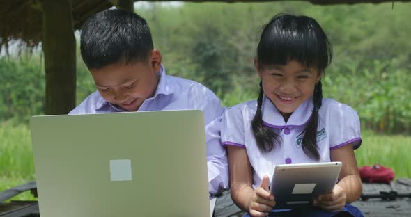 Happy Boy and Girl Using Laptop and Tablet