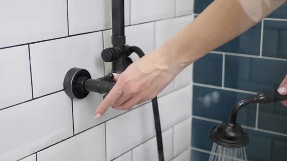 Woman Adjusts the Water Temperature with Tap in the Shower