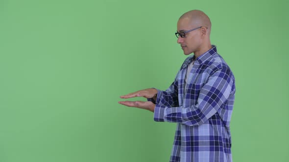 Happy Bald Hipster Man Snapping Fingers and Showing Something