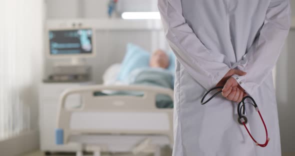 Back View of Doctor Holding Stethoscope Standing in Hospital Ward