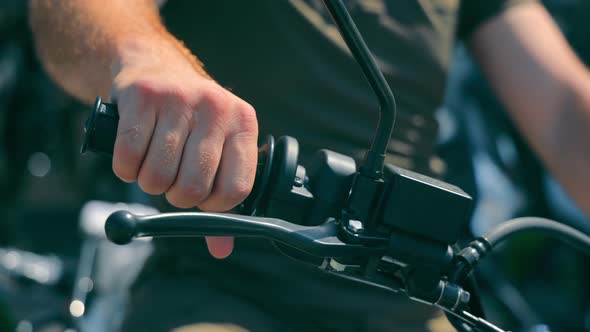 Close Up of a Man's Mitten Hand on the Handlebars of a Motorcycle