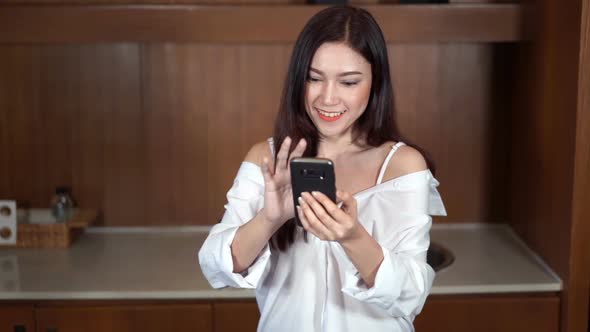 slow motion of woman using her smartphone in kitchen room