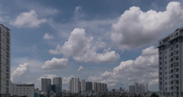 Time lapse of dramatic clouds and blue sky with modern urban  high rise apartment buildings on sides