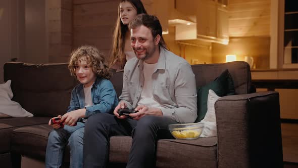 Father Playing with His Son in Game Console and Winning Sitting on Sofa