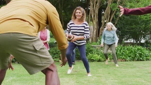 Animation of happy diverse female and male senior friends playing american football in garden