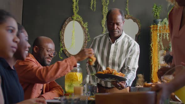 African American Man Taking Care of Guests at Family Dinner