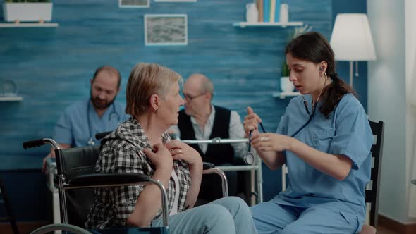 Medical Assistant Using Stethoscope on Senior Patient