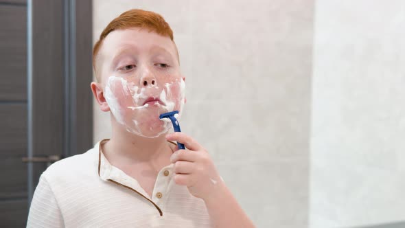 Little Boy is Shaving His Face in the Bathroom