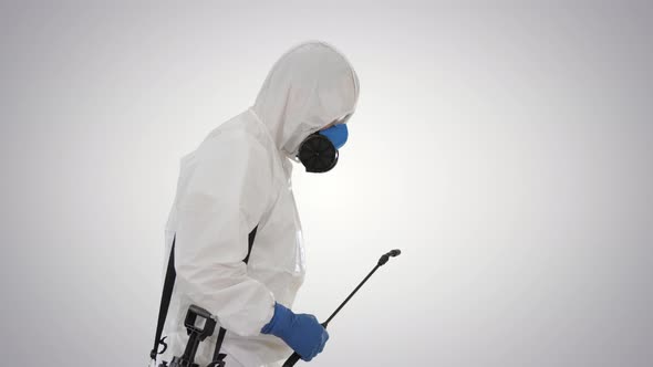 Worker in Hazmat Suit and Face Protection Mask Walking With Disinfection Equipment on Gradient