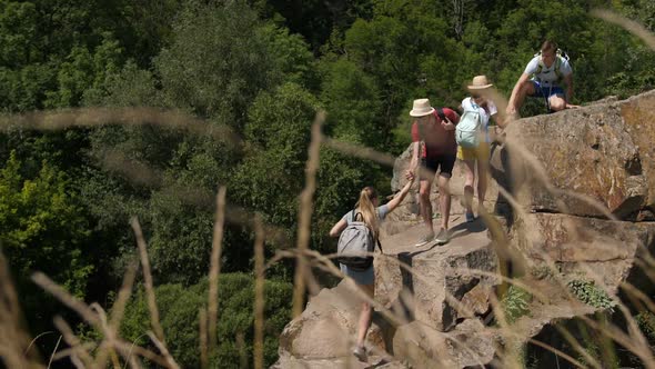 Group of Tourists Climbing Up Rocky Mountain