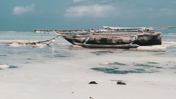 Old Dry African Fishing Rowboat Stranded in Sand on Beach at Low Tide Zanzibar
