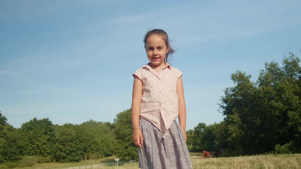 Portrait of a Little Girl Looking at the Camera in the Park