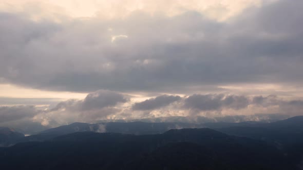 Aerial time lapse of fog over hills after rain, at sunrise