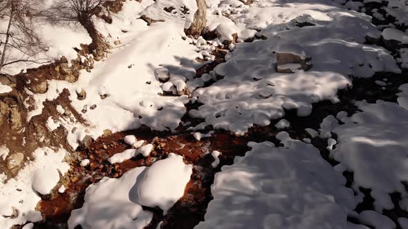 Aerial Slow Motion Over Snowcovered Coast Mountain River Stream