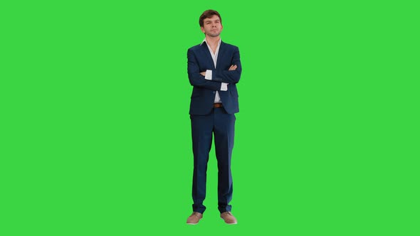 Confident Young Businessman Raising Finger and Folding Arms Looking at Camera on a Green Screen