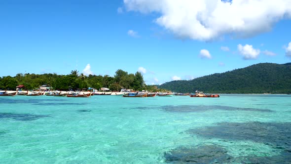 View From Boat on Tropical Island with Boats Near Sea Beach with Green Palm Tree