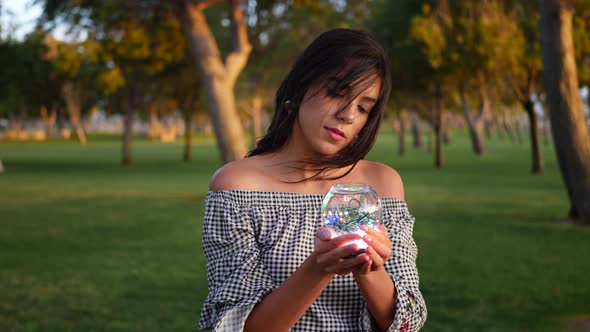 A beautiful gypsy holding a magic glowing crystal ball with an enchanting and mysterious look.