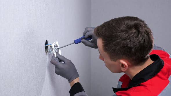 Repairman Guy in Grey Red Jumpsuit Screws New Socket Base