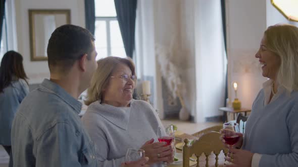 Two Happy Middleaged Women and Man Standing and Talking