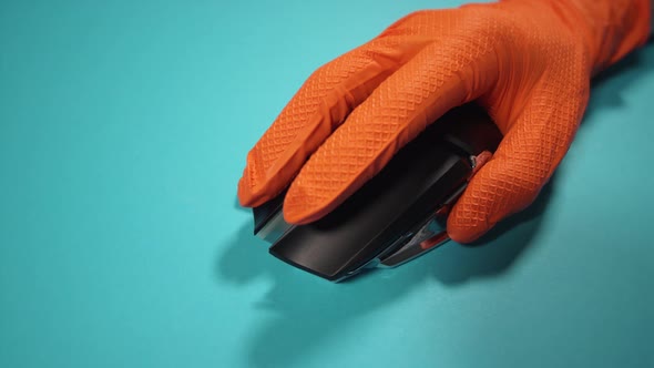Person in Gloves Uses Wireless Mouse on Azure Background