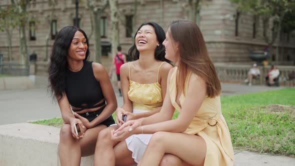 Three Overjoyed Diverse Women Best Friends Enjoying Pleasant Conversation and Laughing Outdoors