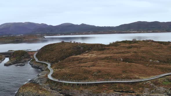 Tourist At The Atlantic Road Walking Pathway On Rugged Coastline In Norway. Aerial Drone Orbit