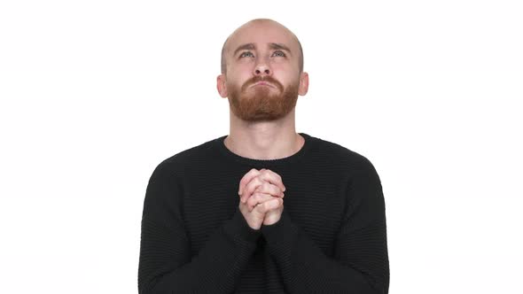 Portrait of Caucasian Man Putting Hands Together and Praying with Face Upward Over White Background