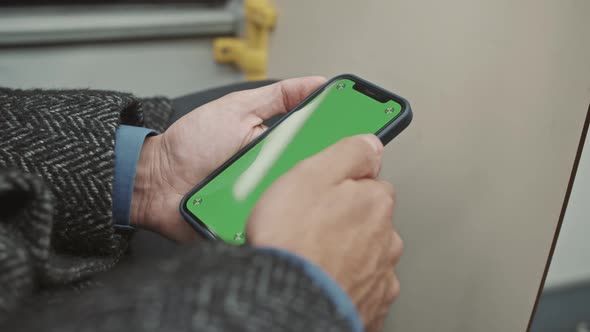 A man uses a smartphone on the bus. Green screen. Phone mockup.