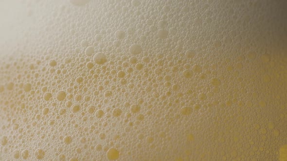 Beer with bubbles into the glass in slow motion