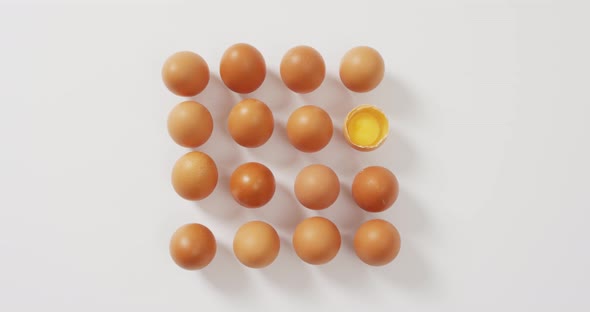 Close up of half broken egg with among other eggs on white surface