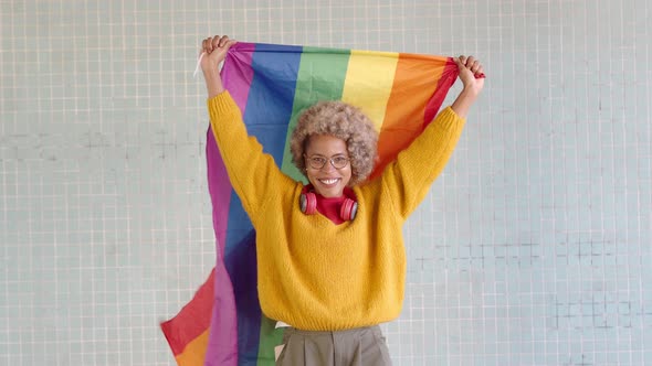 Cheerful African American Woman with Afro Hair and a Lgtb Flag