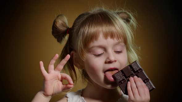 Portrait of Teen Smiling Child Kid Girl with Milk Chocolate Bar Showing Thumb Up Gesture Ok Sign