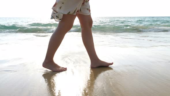 Female Feet Walks Along Empty Ocean Beach