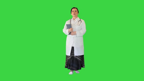 Mature Brunette Female Doctor Walking on a Green Screen Chroma Key
