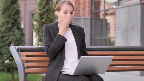 Young Businesswoman in Shock while Working on Laptop Outdoor