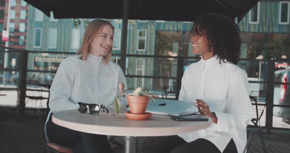 Two women sit and exchange laughs