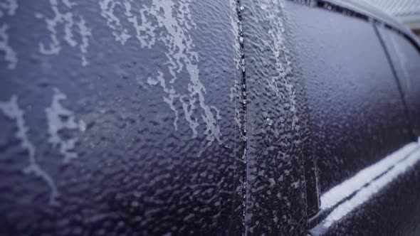 Frozen Body of a Black Car in Winter in Ice